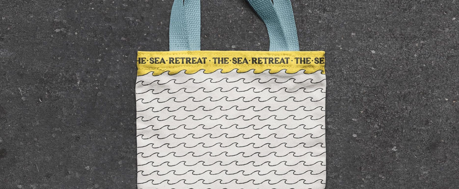 Diseño de bolsa de tela amarilla con las asas de color azul para el alojamiento The Sea Retreat