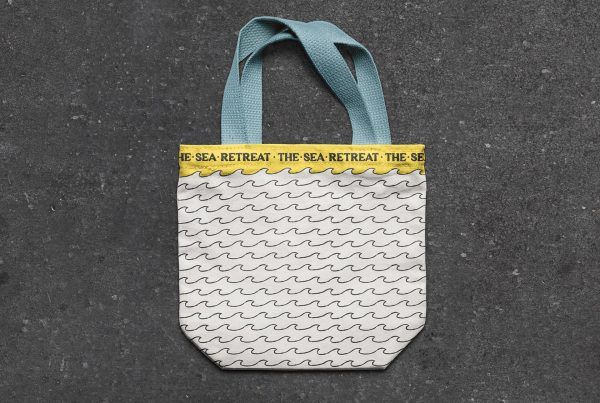 Diseño de bolsa de tela amarilla con las asas de color azul para el alojamiento The Sea Retreat
